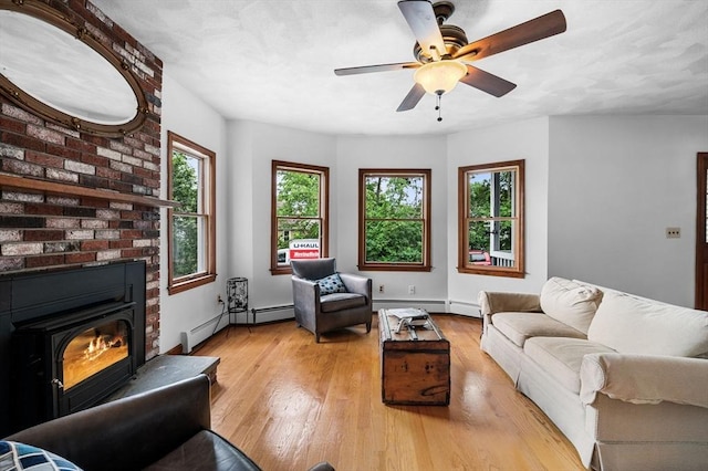 31 Cedar Hill Ter, Swampscott, MA 01907 - living area with a baseboard radiator, light wood-type flooring, baseboards, ceiling fan, and a brick fireplace