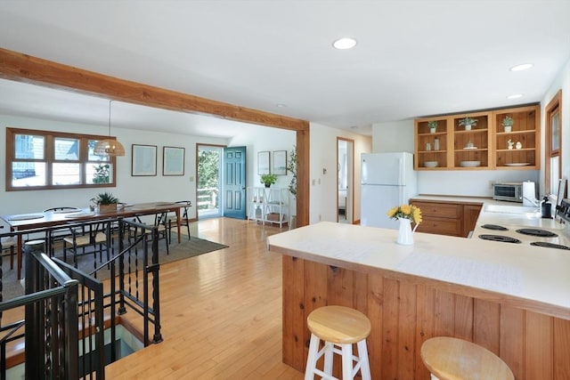 kitchen featuring a healthy amount of sunlight, light wood finished floors, open shelves, and freestanding refrigerator