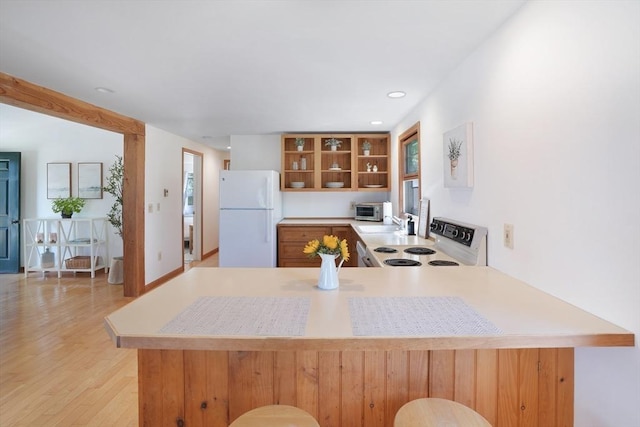 kitchen featuring white appliances, light countertops, open shelves, and a peninsula