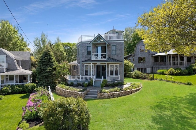 view of front facade featuring a front yard, a balcony, and a porch