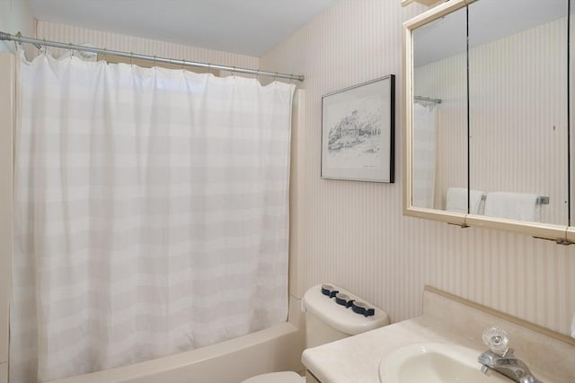 bathroom with wallpapered walls, shower / bath combo, toilet, and vanity