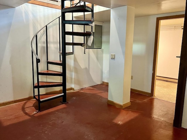 staircase with concrete flooring, baseboards, and baseboard heating