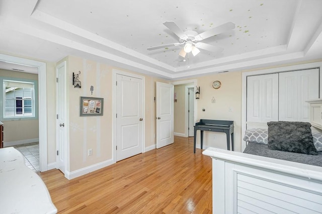 44 Sachem St, Waltham, MA 02451 - interior space with a tray ceiling, light wood finished floors, a ceiling fan, and baseboards