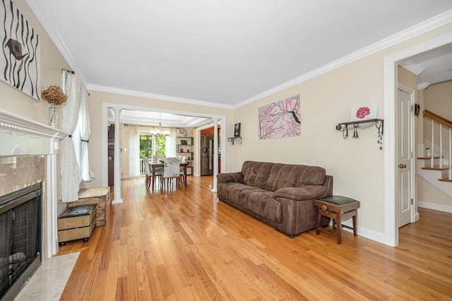 44 Sachem St, Waltham, MA 02451 - living room featuring stairs, crown molding, light wood-style flooring, a premium fireplace, and baseboards