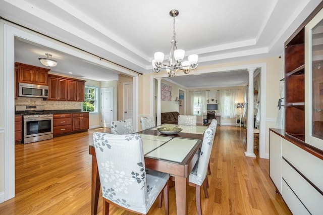 44 Sachem St, Waltham, MA 02451 - dining area featuring ornate columns, light wood finished floors, a chandelier, and a raised ceiling