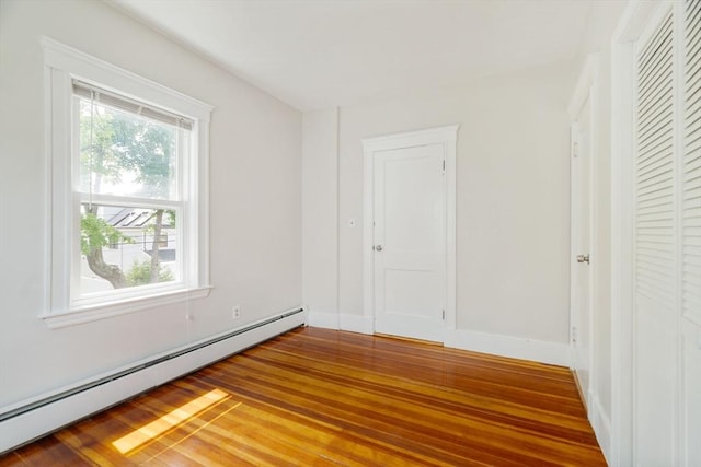 204 Maple St, Boston, MA 02132 - unfurnished bedroom featuring a baseboard heating unit and wood finished floors