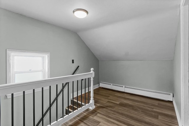 additional living space featuring dark hardwood / wood-style flooring, vaulted ceiling, and baseboard heating