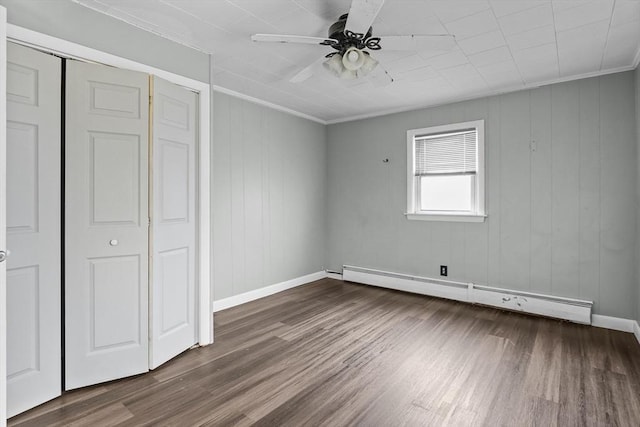 unfurnished bedroom with ceiling fan, crown molding, a baseboard radiator, hardwood / wood-style flooring, and a closet