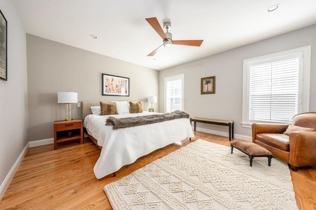 bedroom with baseboards, a ceiling fan, and light wood-style floors