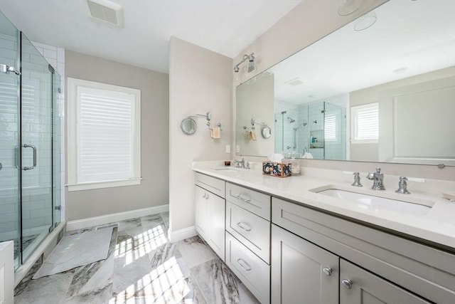 full bathroom with marble finish floor, baseboards, a sink, and a stall shower