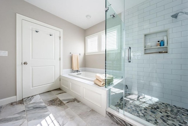 bathroom featuring marble finish floor, a shower stall, and a bath