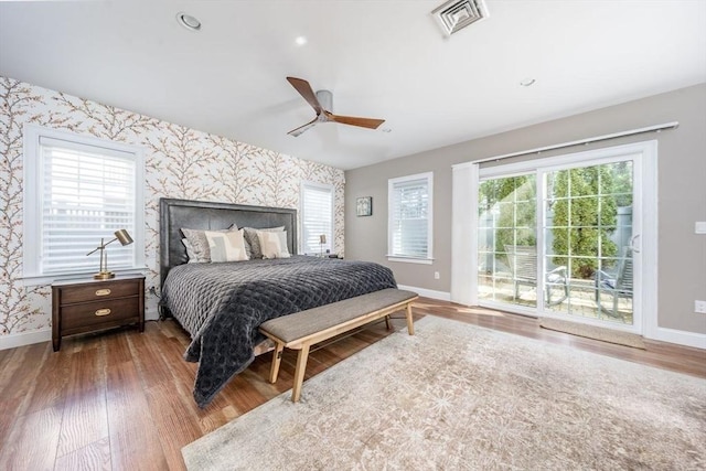 bedroom with access to exterior, visible vents, baseboards, and wallpapered walls