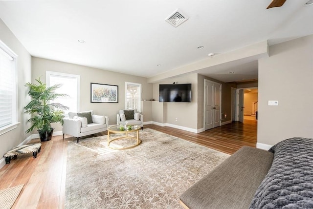 living area with visible vents, baseboards, and wood finished floors