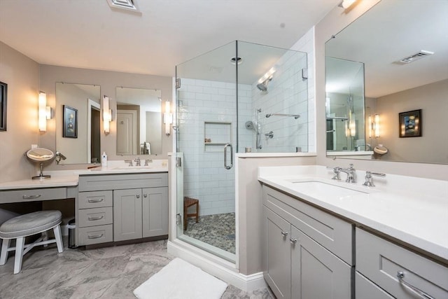 full bath with a stall shower, marble finish floor, visible vents, and a sink