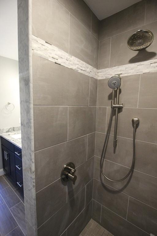 bathroom with vanity and tiled shower