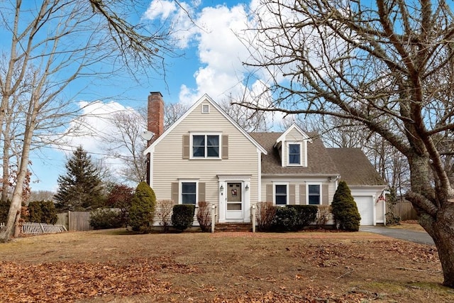 traditional-style house with a garage, fence, driveway, roof with shingles, and a chimney