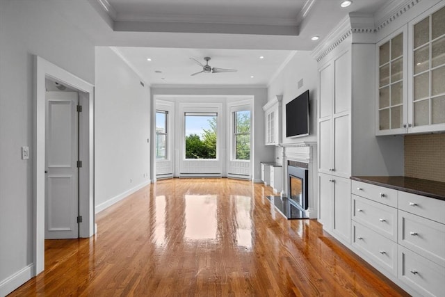 316 Beacon St Unit 1, Boston, MA 02116 - unfurnished living room featuring light wood-style floors, a fireplace with raised hearth, recessed lighting, ornamental molding, and a ceiling fan