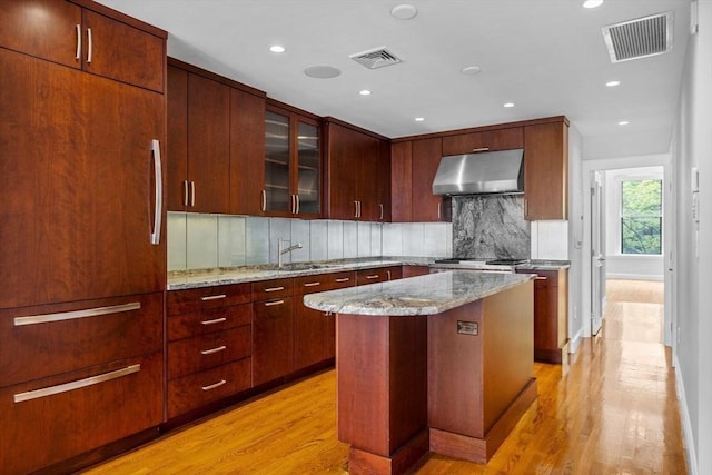 316 Beacon St Unit 1, Boston, MA 02116 - kitchen with extractor fan, light wood finished floors, decorative backsplash, paneled built in fridge, and recessed lighting