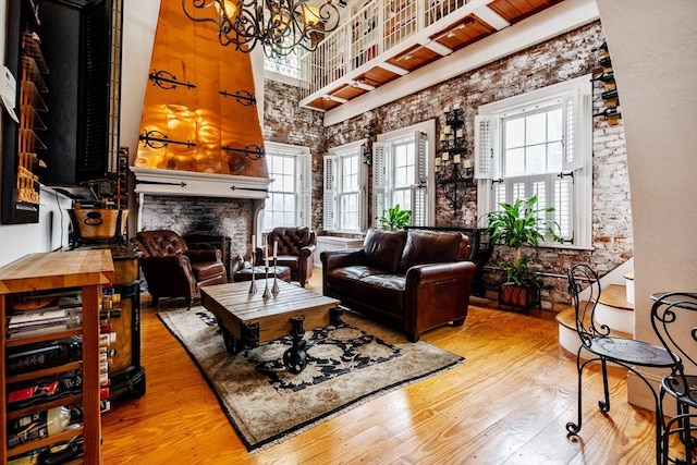 living area with a fireplace, a towering ceiling, wood-type flooring, and a wealth of natural light