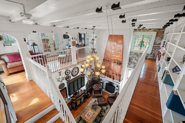 interior space with beamed ceiling, wood-type flooring, a notable chandelier, and wood ceiling