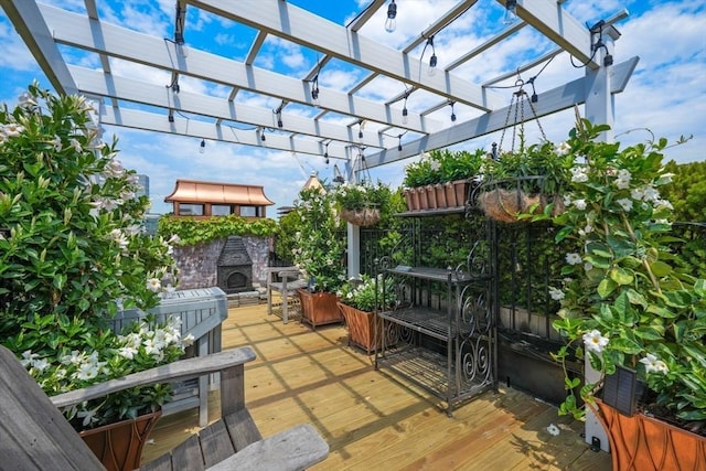 deck with a pergola and an outdoor stone fireplace