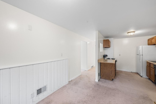 20 Hilltop Dr, Burlington, MA 01803 - kitchen featuring freestanding refrigerator, brown cabinetry, light carpet, and light countertops