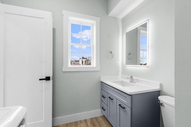 bathroom with hardwood / wood-style floors, vanity, and toilet