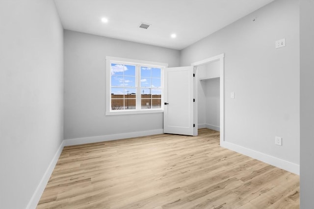 unfurnished bedroom featuring light hardwood / wood-style floors and a closet