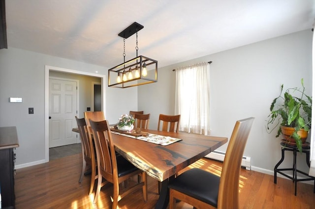 dining space with baseboards, a baseboard heating unit, and wood finished floors