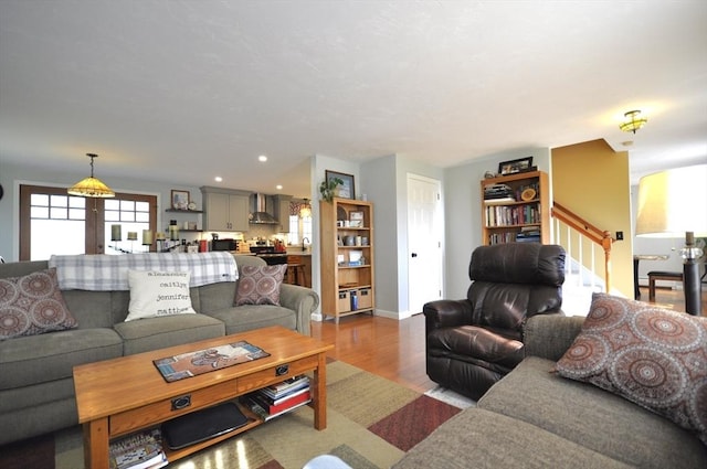 living area with baseboards, recessed lighting, wood finished floors, and stairway