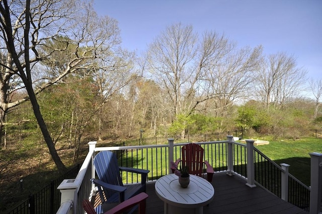 wooden deck with a lawn and fence