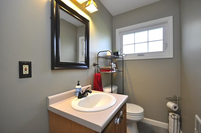 half bath with vanity, baseboards, and toilet