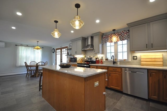kitchen featuring wall chimney range hood, a center island, gray cabinets, a sink, and appliances with stainless steel finishes