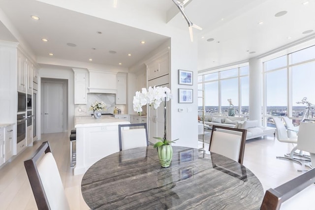 dining area with a wall of windows and recessed lighting