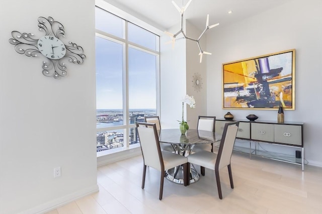 dining space featuring a towering ceiling and baseboards