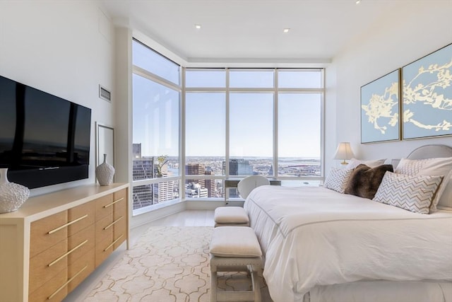 bedroom with a wall of windows and a city view