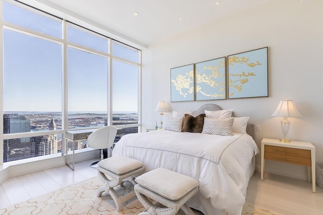 bedroom featuring expansive windows and light wood-style floors