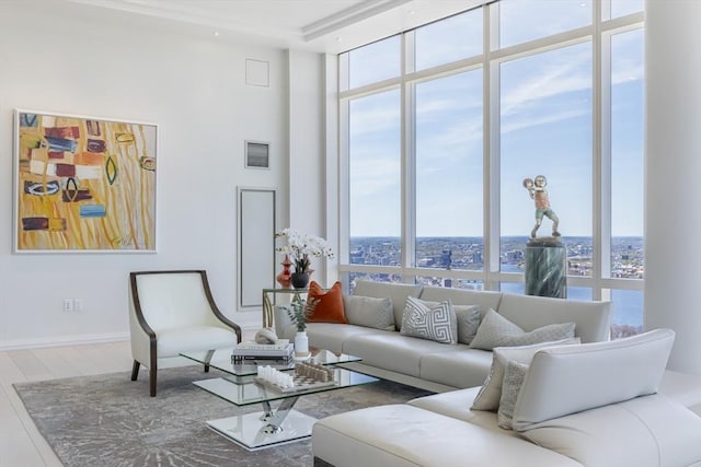 living area with a wall of windows, healthy amount of natural light, wood finished floors, and a high ceiling
