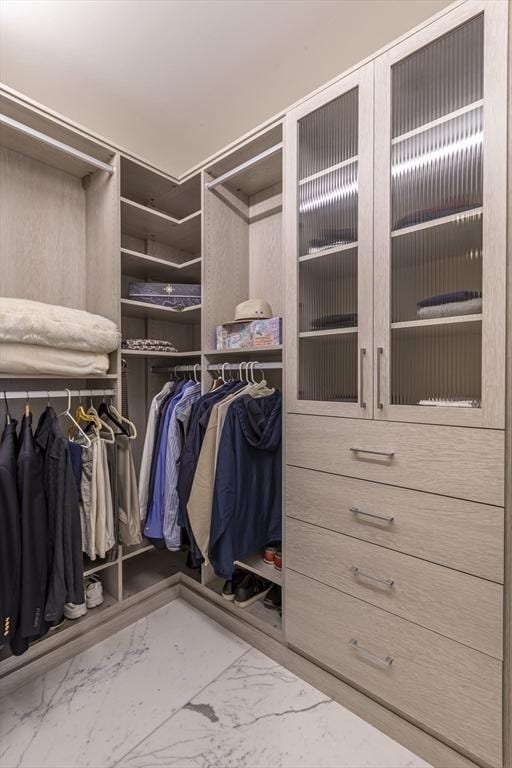 spacious closet with marble look tile flooring