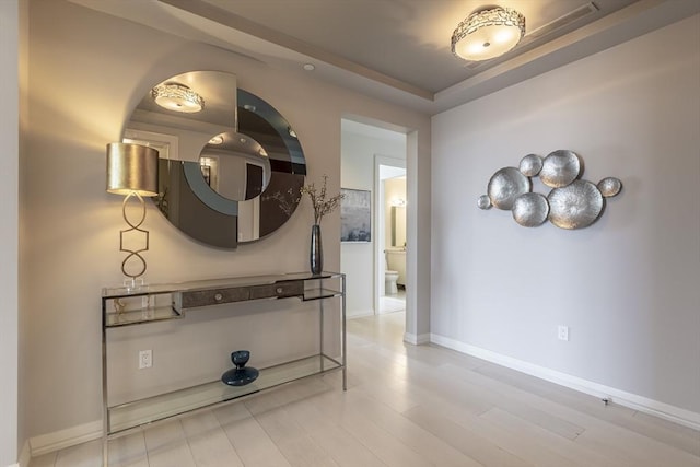 hallway featuring light wood-style floors and baseboards