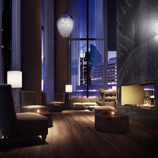 common area featuring a view of city lights and a wall of windows