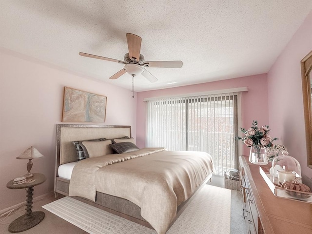 carpeted bedroom featuring access to outside, a textured ceiling, and ceiling fan