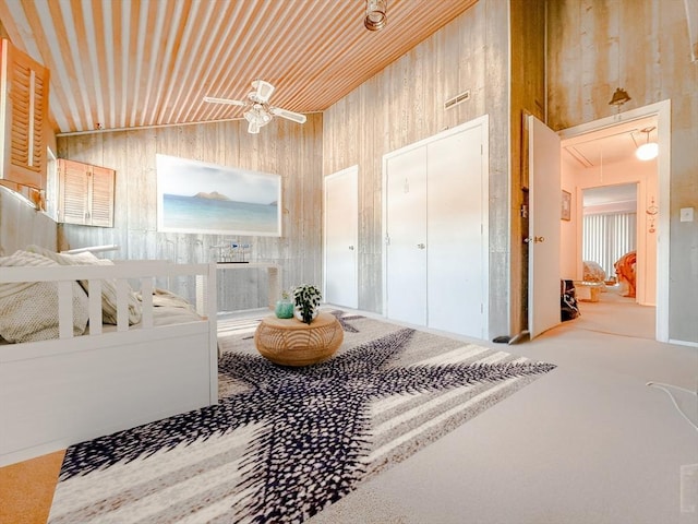 corridor featuring attic access, wooden walls, and vaulted ceiling