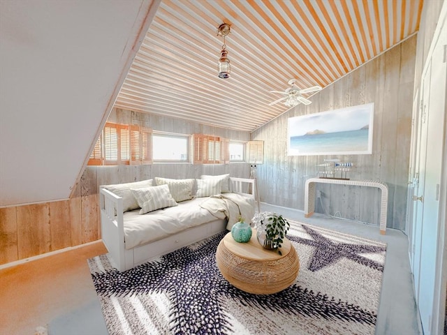 living area featuring wooden walls, lofted ceiling, and a ceiling fan