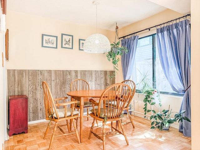 dining space featuring baseboards and wooden walls