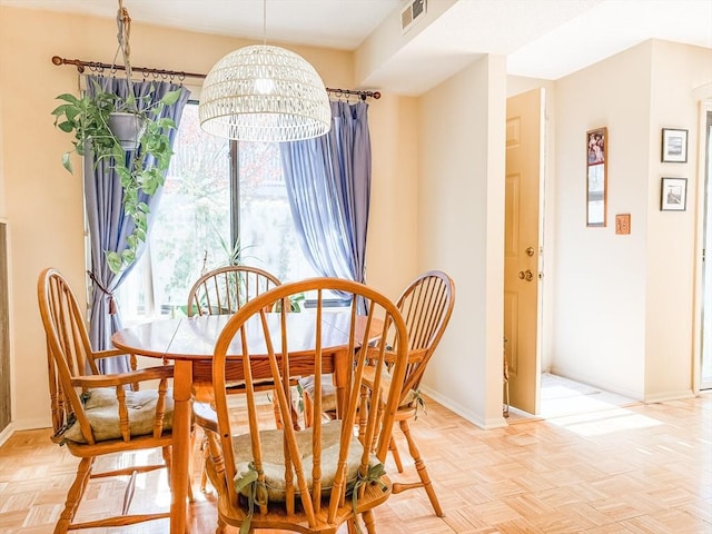 dining area featuring a chandelier and baseboards