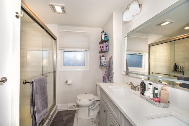 bathroom featuring vanity, a shower with door, and toilet