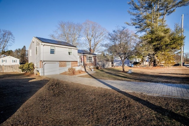 view of front of property featuring a garage and solar panels