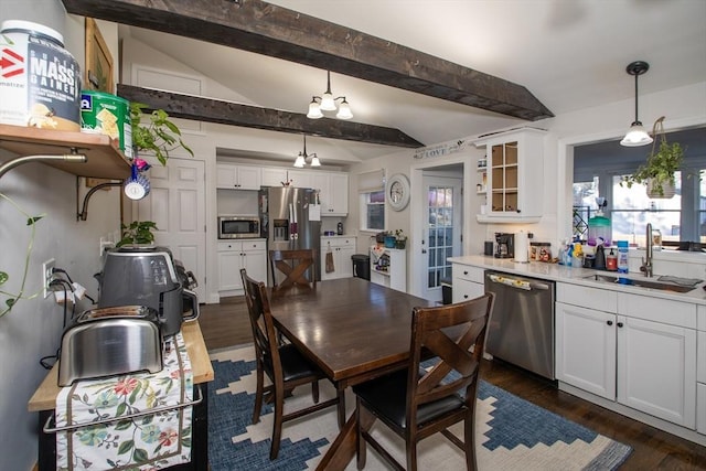 dining room featuring dark hardwood / wood-style flooring, sink, and lofted ceiling with beams