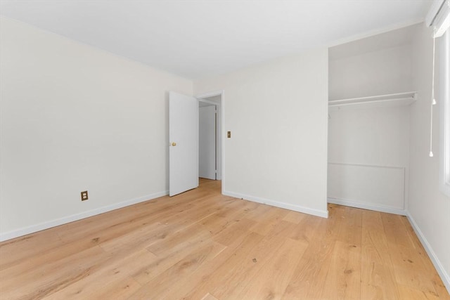 unfurnished bedroom with a closet, baseboards, and light wood-style floors